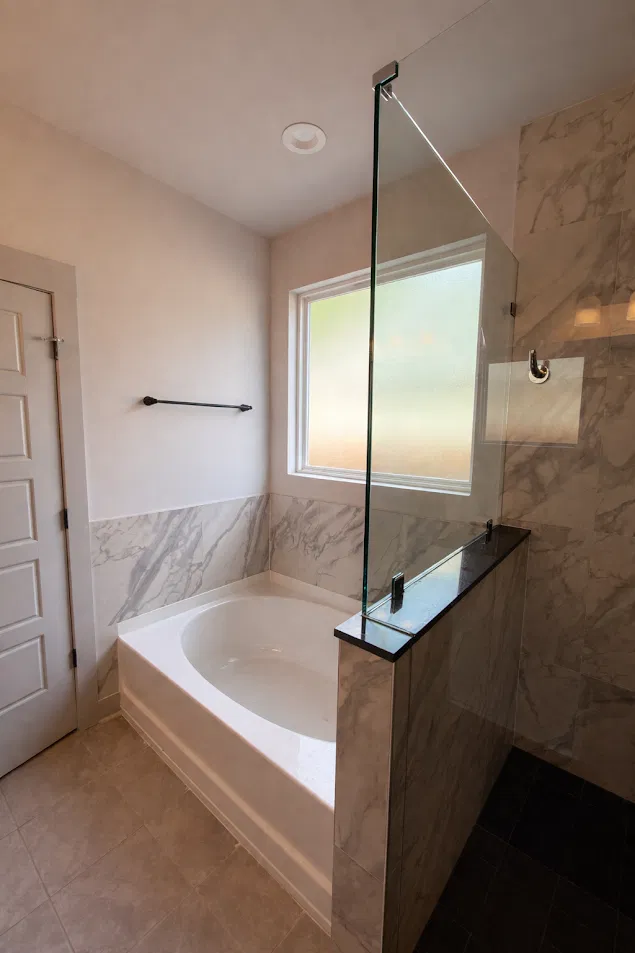 Tub and shower combo with marble look tile surround by CNB Renovations Charleston SC